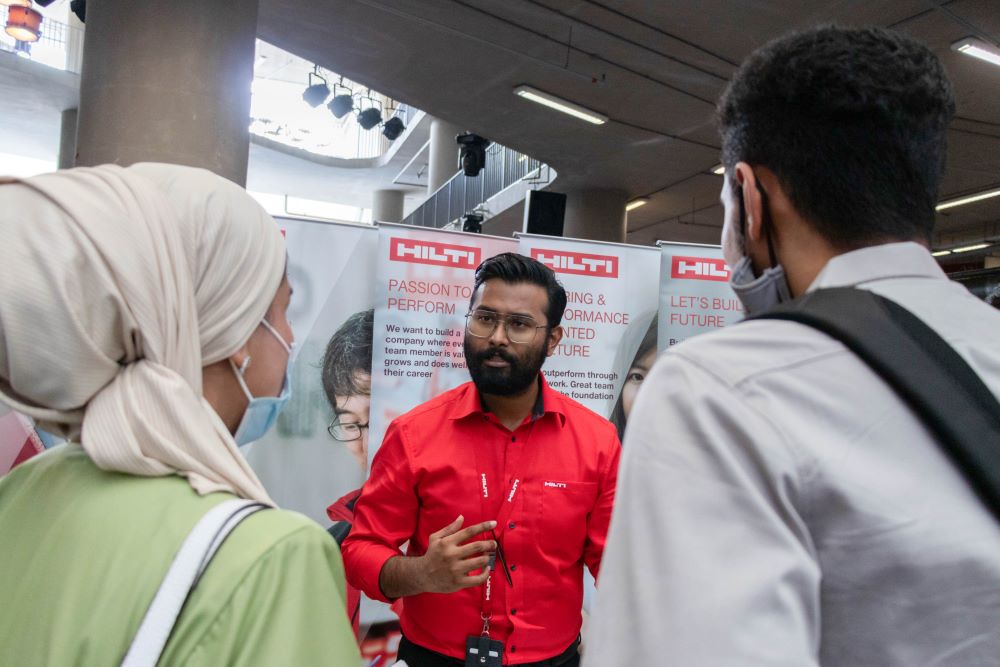 A representative from Hilti Corporation explains the job offered to the booth visitors. 